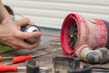 Drainage pump. A man is lubricating a drainage pump with oil.