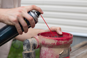 Drainage pump. A man is lubricating a drainage pump with oil.