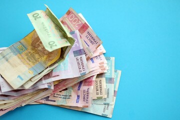 Ukrainian money bills on light blue paper background