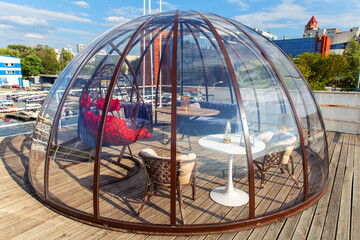 Transparent domed gazebo in the style of an igloo for romantic dates of lovers. Open air restaurant