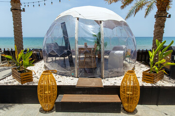 Transparent domed gazebo in the style of an igloo for romantic dates of lovers. Open air restaurant