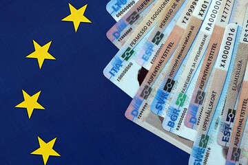 Permanent resident or residence permit cards lies on European Union flag. Specimen cards close up