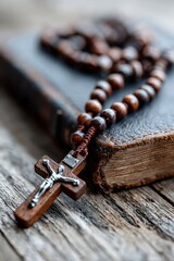 Wooden rosary laid on an old book resting on a rustic wooden table