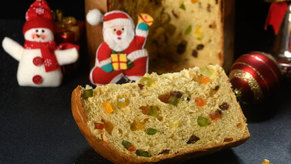 Delicious slice of panettone with candied fruit and Christmas decorations