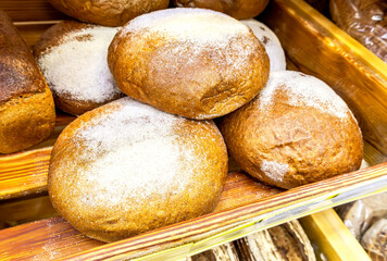 Freshly baked  loaves of bread displayed on wooden shelves in bakery