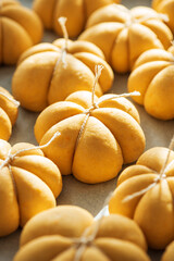 Pumpkin-Shaped Dough Pieces Tied with String on Baking Sheet