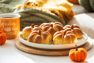 Autumn Table Setting with Pumpkin-Shaped buns with Cinnamon, Apples, Pumpkins, and Cozy Decor