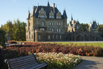 Obraz premium Panoramic view of the Gothic castle and the adjacent park area with flower beds.