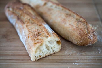 Aufgeschnittenes Baguette auf Holzbrett 