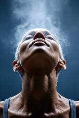 Woman breathing deeply with smoke rising against a dark background during a meditative moment