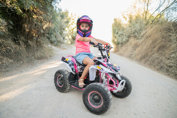 Girl driving quad bike on dusty dirt road © KikoStock
