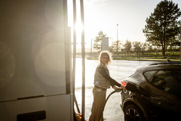 Frau tankt Auto an der Autobahn 