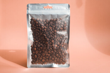 Blank craft plastic pouch mock up with coffee beans inside, transparent pack on studio background with shadow, mylar bag isolated for coffee product
