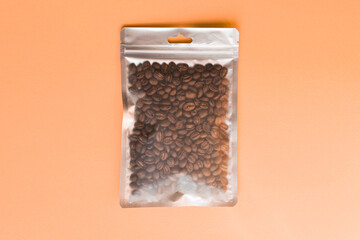 Blank craft plastic pouch mock up with coffee beans inside, transparent pack on studio background with shadow, mylar bag isolated for coffee product