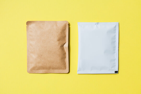 Blank craft plastic pouch, white pack on studio background with shadow, mylar bag isolated for coffee or food, cosmetic products, snack, candy. Different sizes, mock up.