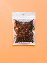 Blank craft plastic pouch mock up with coffee beans inside, transparent pack on studio background with shadow, mylar bag isolated for coffee product