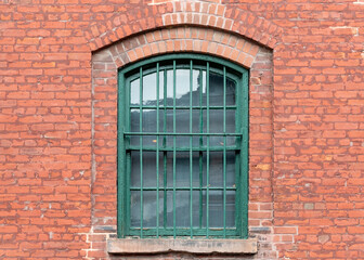 Fototapeta premium old green window with red brick wall at distillery district Toronto Ontario