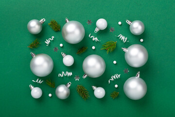 Grey Christmas balls with decor on color background, top view