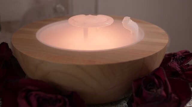 Close-up of an ultrasonic aroma diffuser with warm light emitting mist and gentle bubbling sound, creating a calm and relaxing atmosphere