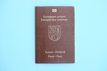 Finland passport on light blue paper background close up. Citizenship and travel in Europe concept