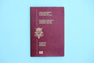 Belgium passport on light blue paper background close up. Citizenship and travel in Europe concept
