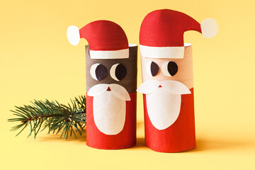 Christmas toy from toilet tube roll, paper toy santa claus, snowman, reindeer, tree rabbit on yellow background. Holiday easy kids DIY, decoration idea for winter season, home party. Children's crafts