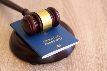Judge mallet and ukrainian passport on brown background. Passport Of Ukraine. Obtain citizenship