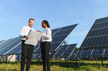 Engineers discussing blueprint at solar power plant