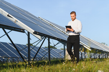 Engineer checking solar farm performance using tablet