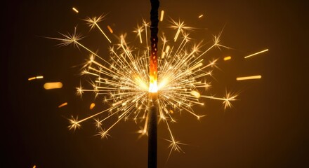Burning Sparkler Firework with Golden Sparks Against Warm Brown Background for Celebration, Festivity, and New Year Holiday Event in Macro Detail