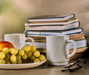 Cozy autumn study still life - Books, coffee mugs and fruit - An academic and relaxing autumn scene featuring books, glasses, and a healthy snack