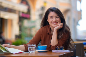 Woman tourist smiling planning city break in cafe