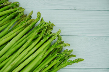 Bunch of fresh green asparagus stems on wooden background