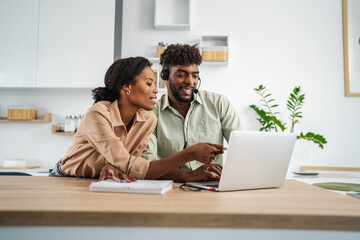 Obraz premium Couple collaborating on remote work using laptop and headset
