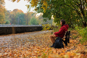 man sitting on the bench in autumn park