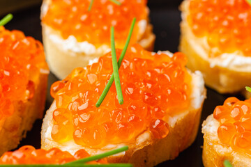 Close-up of red caviar canapes with chives decoration