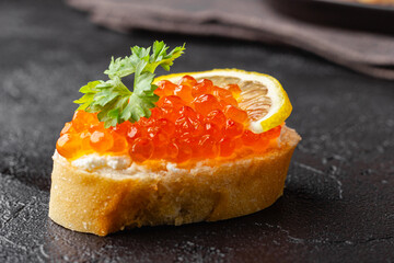 Red caviar canape with lemon and parsley garnish