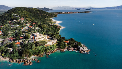 Naklejka premium Ilha Praia Litoral Fortaleza Forte Português Verão Guarda Sol Areia Mar Oceano Paisagem Natureza Turismo Viagem Beira Mar Cênico Tropical Azul Horizonte Reflexo Costeira Brasil Santa Catarina Floripa