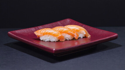 Salmon nigiri sushi pieces on a red square plate with a dark background, showcasing Japanese culinary art. The sushi features fresh salmon slices on sushi rice. Image made using Generative AI.