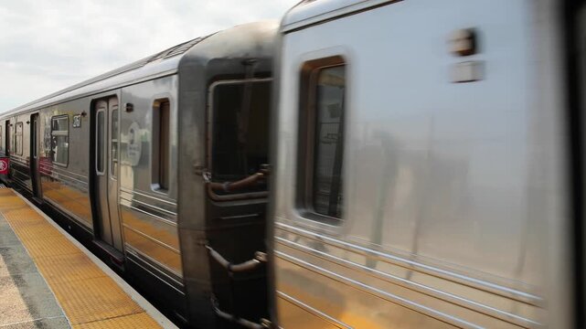 overhead above ground subway train passing train station in bensenhurst brooklyn new york city (nyc metro rail commuter line system) travel commute elevated tracks pass moving move cars car transport