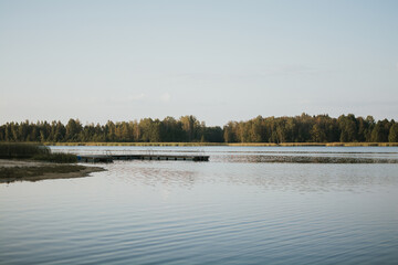 Lake with reflections of trees and forest in the distance in Estonia