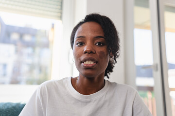 Calm small business entrepreneur recording a video message from her home workspace, speaking with focus and authenticity in a natural daylight setting
