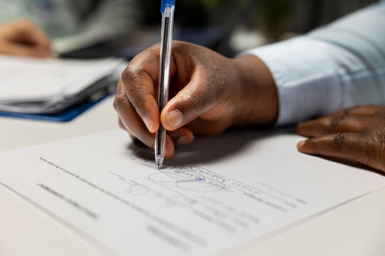 Fototapeta Close up of black candidate signing legal contract paper during HR meeting, beginning the hiring process and onboarding journey. Exciting multinational company job position. Career growth.