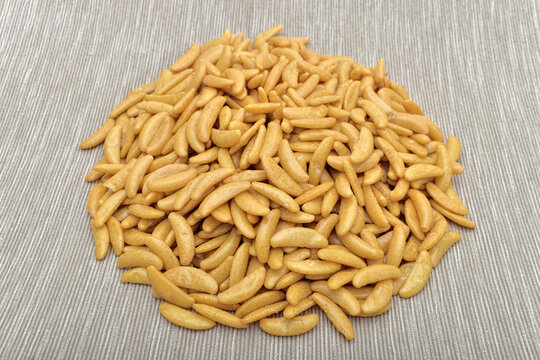 Japanese rice crackers kaki no tane on light gray textured surface.