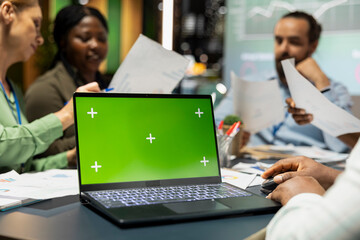 Business colleagues meeting at night in the office with a green screen, team members exchange...