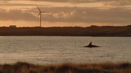 Wind turbine blades rotating gracefully near the coastline with a submersible silhouette out of focus in the foreground showcasing wind energy integration.