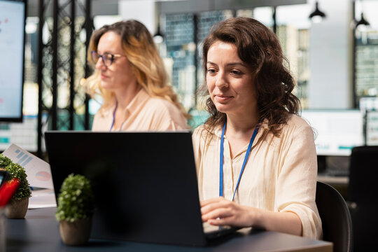 Female business entrepreneur works in boardroom and solving tasks, immersed in report writing during a briefing session with her team. Using indicators to plan a successful project. - Powered by Adobe