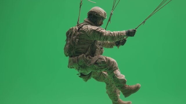 Action shot of military paratrooper hooking static line with focused expression highlighting discipline and airborne mission readiness on green screen.