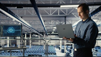 Data center IT professional deploys deep learning software on infrastructure racks. Server farm engineer trains AI systems with datasets using laptop to support applications, camera A