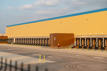 A modern logistics hub for goods and packages ready for shipment, an automated warehouse with truck loading and unloading areas for e-commerce and product distribution. Freight and product transport. 